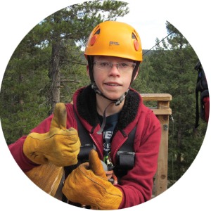 Photo of a boy with a helmet at an adventure camp in the forest.