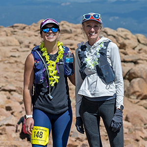 Woman hiker at the summit of Pikes Peak giving the sign for "peace".